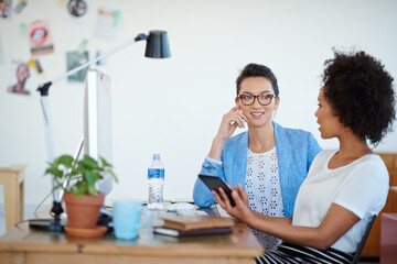 Shot of an attractive young woman sitting at her workstation in the office. The commercial designs...