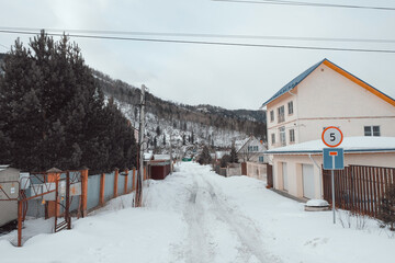 Fototapeta premium March in the village of Mansky, the snow began to melt, wooden cottages