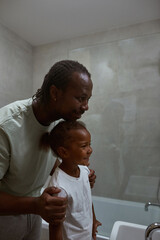 Father hugging daughter and they looking at mirror