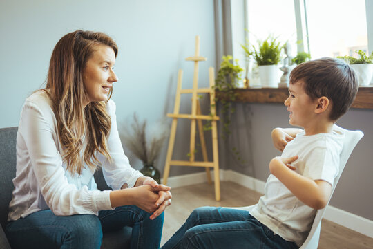 Young boy having therapy with a child psychologist. Shot of a young child psychologist talking with a boy. Friendly young child psychologist talking with little boy suffering from emotional disorder