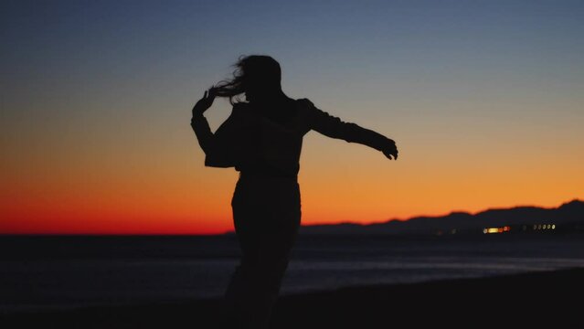 silhouette of a dancing girl at sunset light