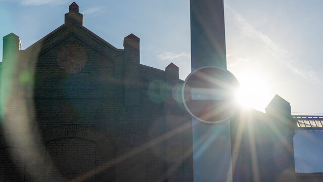 No entry sign in an old town with lens flare. Red no entry traffic sign on old building background.
