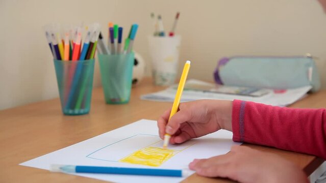 litle child hand draws the flag of Ukraine