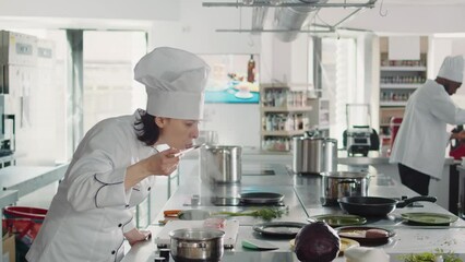 Woman working as cook testing bad soup for gourmet dish, making mistake in preparing culinary recipe. Authentic chef doing taste test with sauce, cooking in professional gastronomy kitchen.