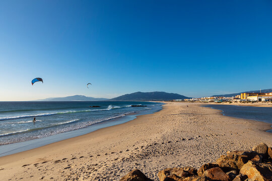 beach of Tarifa in Spain, with people kite surfing in the background 