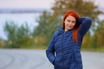 portrait of a life style woman with red hair in autumn against a background of colorful foliage