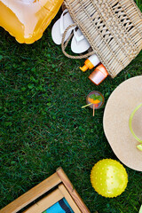 Fototapeta premium Flat lay of outdoor bright summer beach vacation or travel lifestyle concept on grass background, top view, copy space..