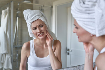 Caucasian woman  in the bathroom having a strong toothache