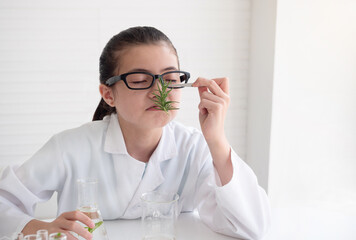 Young science smell plant in elementary science class. Science laboratory concept.