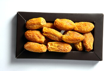 Fresh almonds in the wooden bowl, Organic almonds, almonds border white background, Almond nuts on a dark wooden background. Healthy snacks. Top view. Free space for text.