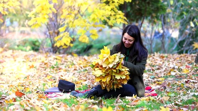 woman making wreath from the yellow maple leaves