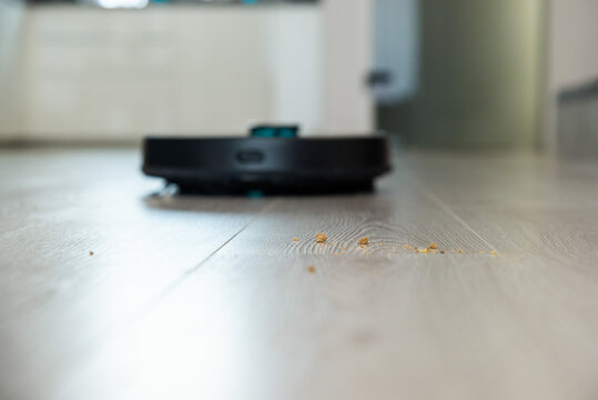 Robot vacuum cleaner is cleaning floor, close on dust