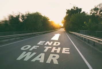 The empty road in the forest and the text on the asphalt "The end of the war".