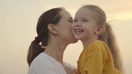 Happy child kid mother arms. happy family concept. teamwork. little daughter kissing mom. weekend rest. cheerful active girl daughter. child's love for parent. kid play mom arms. happy family park.