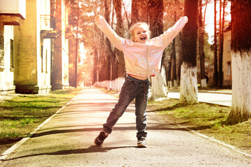 Happy little girl with her hands up outdoors. Freedom and carefree. Happy childhood. Retro haze...