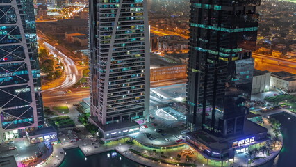 Fototapeta na wymiar Tall residential buildings at JLT aerial night timelapse, part of the Dubai multi commodities centre mixed-use district.