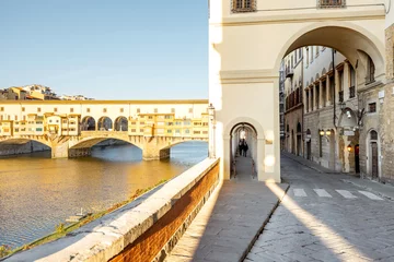 Photo sur Plexiglas Ponte Vecchio Morning view on famous Old bridge called Ponte Vecchio and arcade on Arno river in Florence, Italy. Concept of traveling Italy and visiting italian landmarks