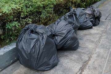 Garbage bags, black bin bags, on the foot path. Environment and object concept.