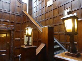 Wood panels and old lights on a stairway in an old inn