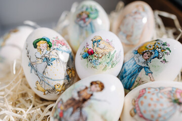 Close-up of different drawings on goose eggs for Easter festival. Eggs on hay. Hand made print. Spring hollidays. Easter concept