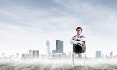 scared businessman on a chair