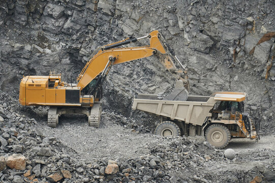Grosser Tiefl&ouml;ffelbagger bel&auml;dt Muldenkipper mit Felsmaterial in einem Kalksteinbruch