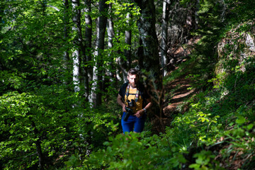 Naklejka premium man using binoculars while trekking in nature