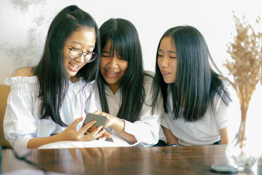 group of asian teenager reading message in smart phone