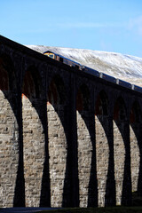 Train passing over ribblehead viaduct, yorkshire dales, in winter