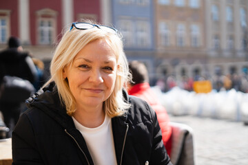 Mature 50s caucasian woman with blond hair outdoors on sunny day. European travel 