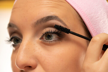 Close up crop of a woman applying mascara