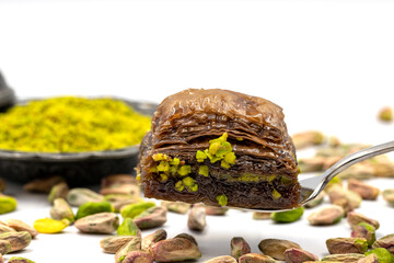 Fototapeta na wymiar Chocolate baklava with pistachio on a white background. Traditional Turkish cuisine delicacies. Local name is fıstıklı çikolatalı baklava