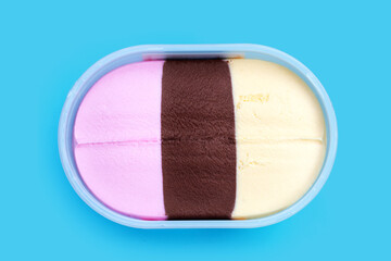 Ice cream in plastic box on blue background.