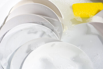 Dish washing, Dirty dishes soaking in kitchen sink.