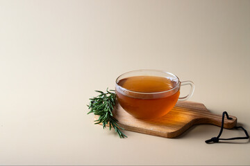 Herbal rosemary tea in a glass cup on oriental background, horizontal
