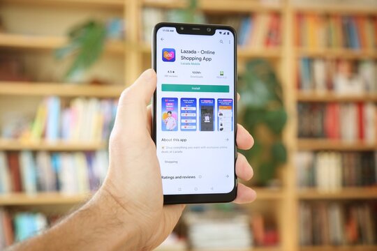 WARSAW, POLAND - JANUARY 29, 2021: User installing Lazada online shopping mobile app on an Android OS, Xiaomi smart phone.