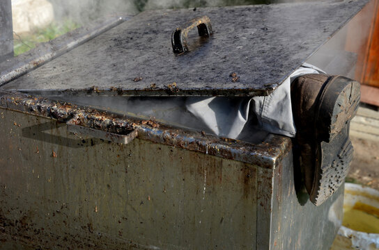 repair piping with hot water steam in hatch of device. only shoes and feet look out of tank. smoke rolls in winds which rolls fog, dust. stainless steel kitchen equipment washes inside men, film, army