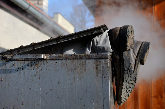 repair piping with hot water steam in hatch of device. only shoes and feet look out of tank. smoke rolls in winds which rolls fog, dust. stainless steel kitchen equipment washes inside men, film, army
