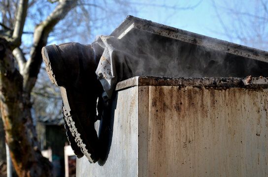 repair piping with hot water steam in hatch of device. only shoes and feet look out of tank. smoke rolls in winds which rolls fog, dust. stainless steel kitchen equipment washes inside men, film, army