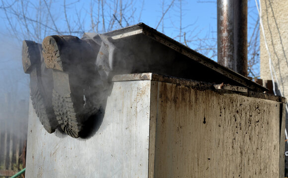 repair piping with hot water steam in hatch of device. only shoes and feet look out of tank. smoke rolls in winds which rolls fog, dust. stainless steel kitchen equipment washes inside men, film, army