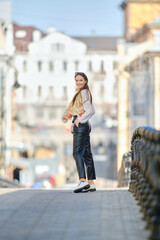 Cheerful woman walking on pavement in sunny day