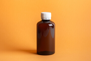 Clean brown jar for cosmetics on an orange background
