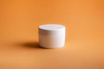 White clean package for body cream on orange background