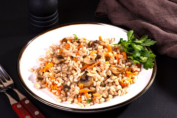 Easy bulgur pilaf (pilavi) with tomatoes in a ceramic bowl on a dark background close-up.