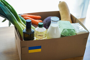 Food box for ukrainian war refugees - Humanitarian help and aid concept - Focus on Ukraine flag