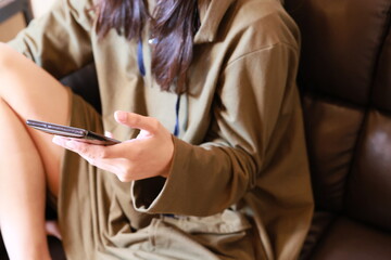 Obraz na płótnie Canvas ソファーでスマートフォンを見る女性