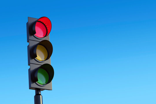 Red traffic light with sky background