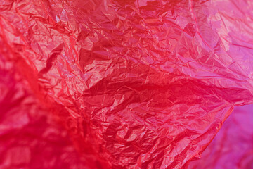 The texture of a crumpled pink package with selective focus, pink abstraction