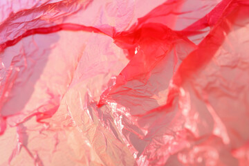 The texture of a crumpled pink package with selective focus, pink abstraction