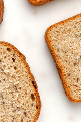 Slices of a whole wheat bread on a marble tray. Four pieces. Healthy Hand Made Bread